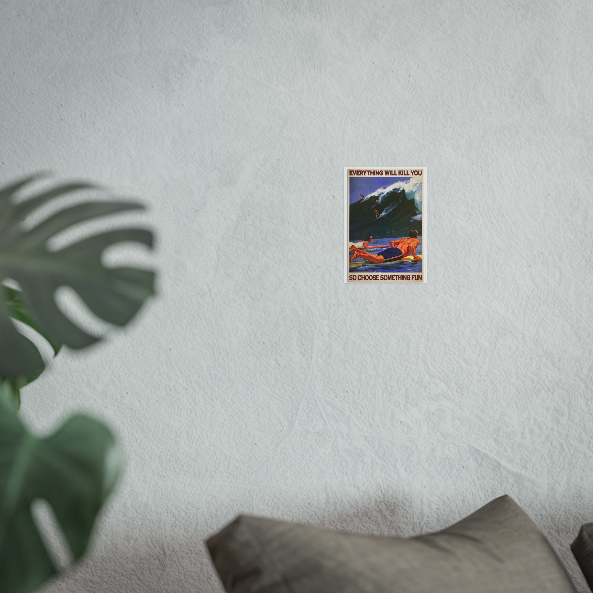 Framed wall poster with small surf scene and quote text, surrounded by leafy plant